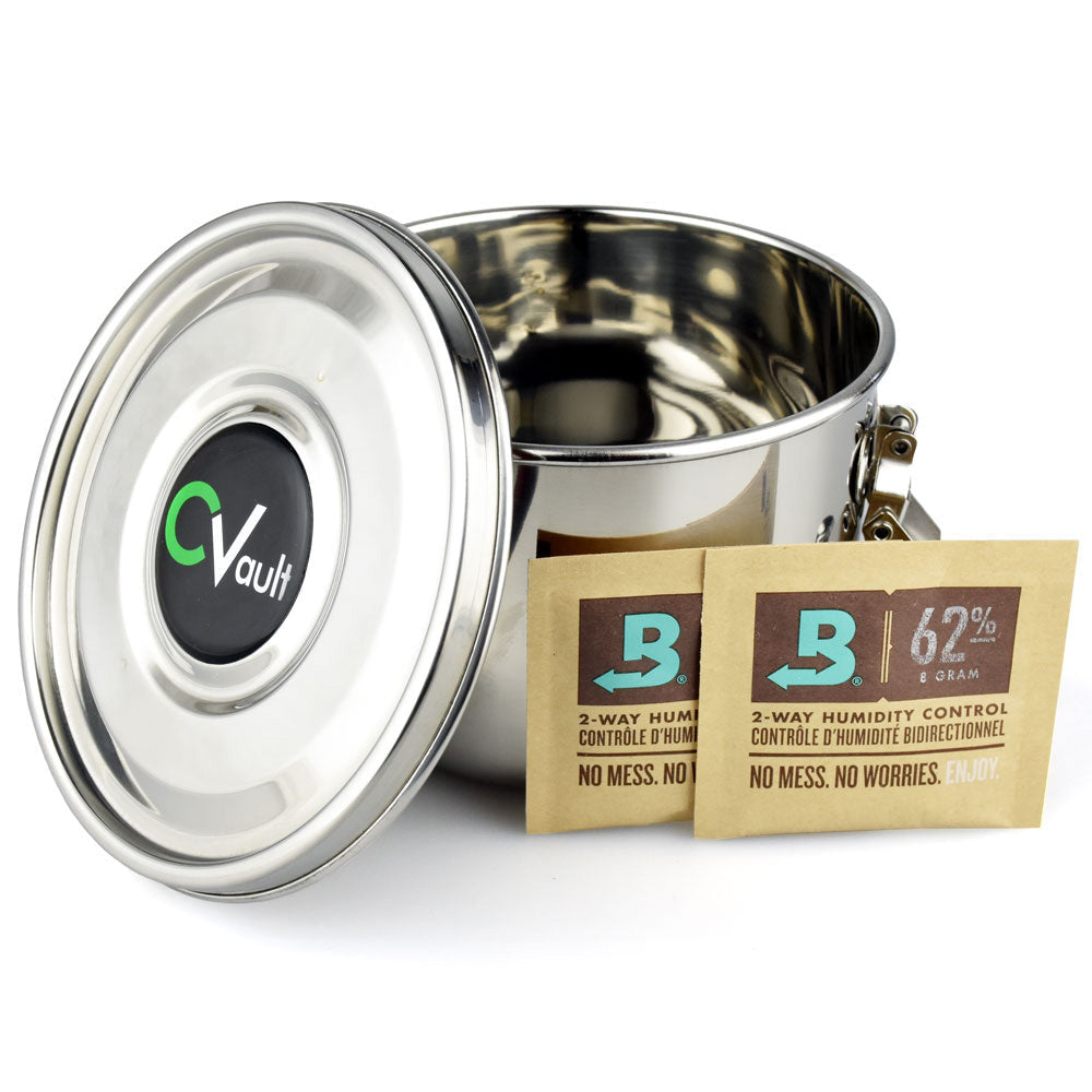 Metal weed container with a lid and two brown boveda packages on a white background