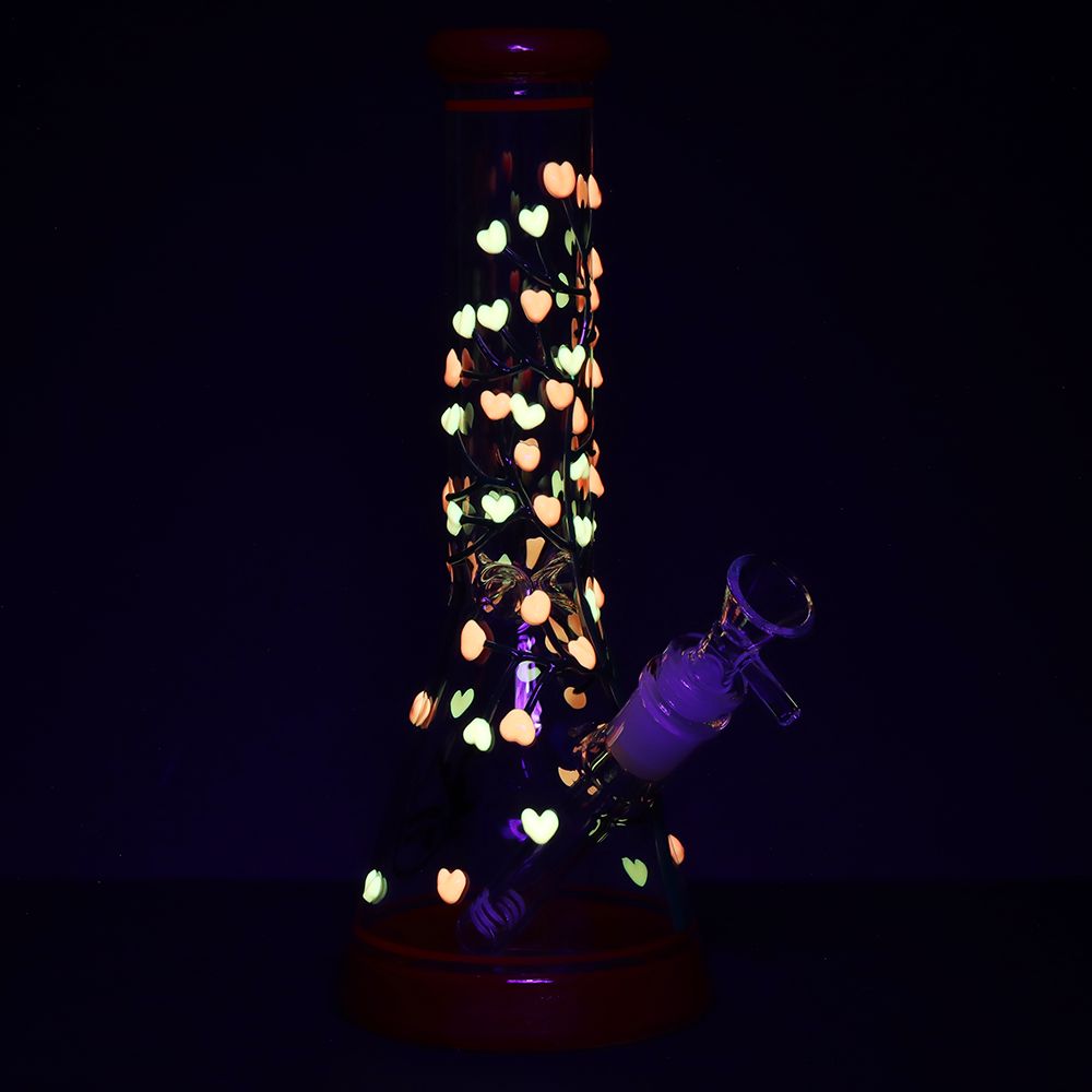 Glowing heart-shaped lights inside a glass bong on a black background