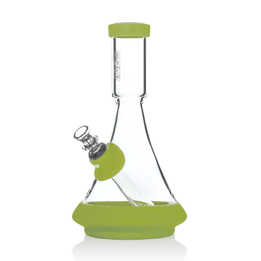A clear glass beaker bong with a green silicone base and a green mouthpiece.