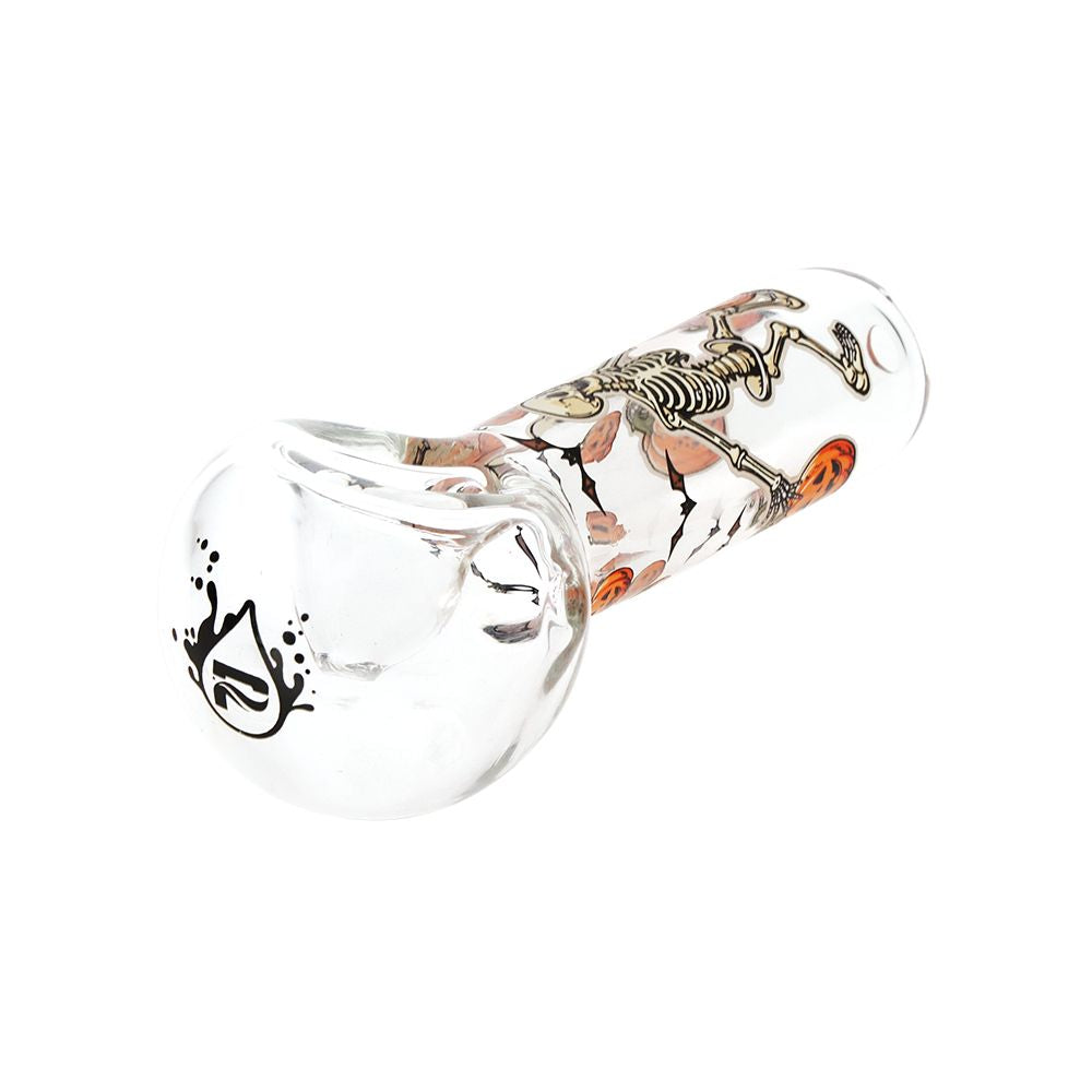 A clear glass water pipe with a skeleton and orange pumpkin design on the neck, featuring a black logo on the bowl, shown against a plain white background.