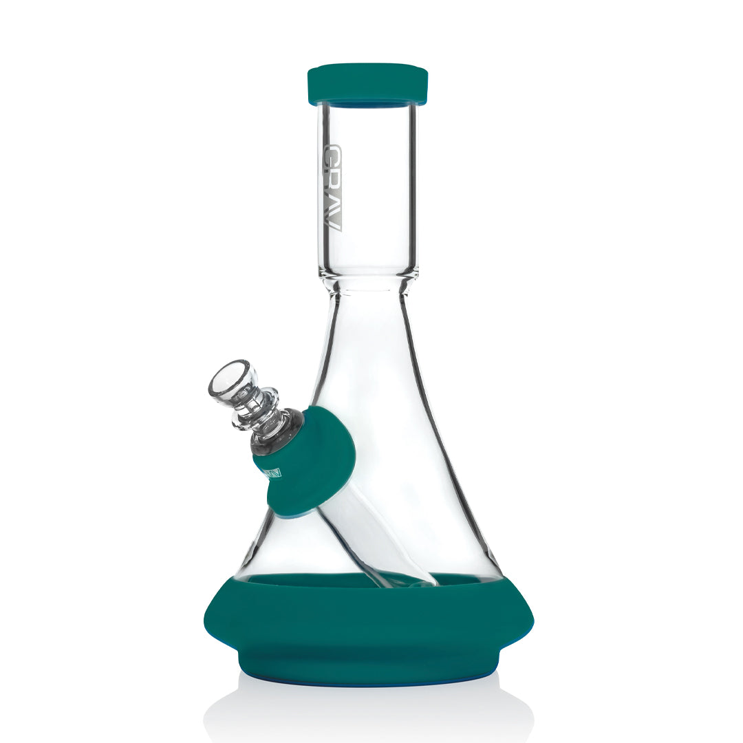 A clear glass beaker bong with a teal silicone base and a green mouthpiece.