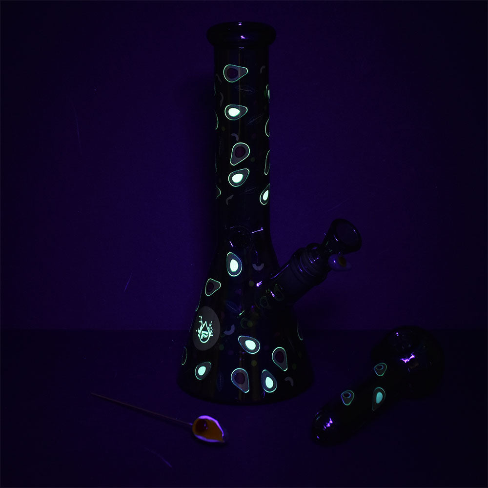 Black glass water pipe with glowing avocado patterns on a dark background